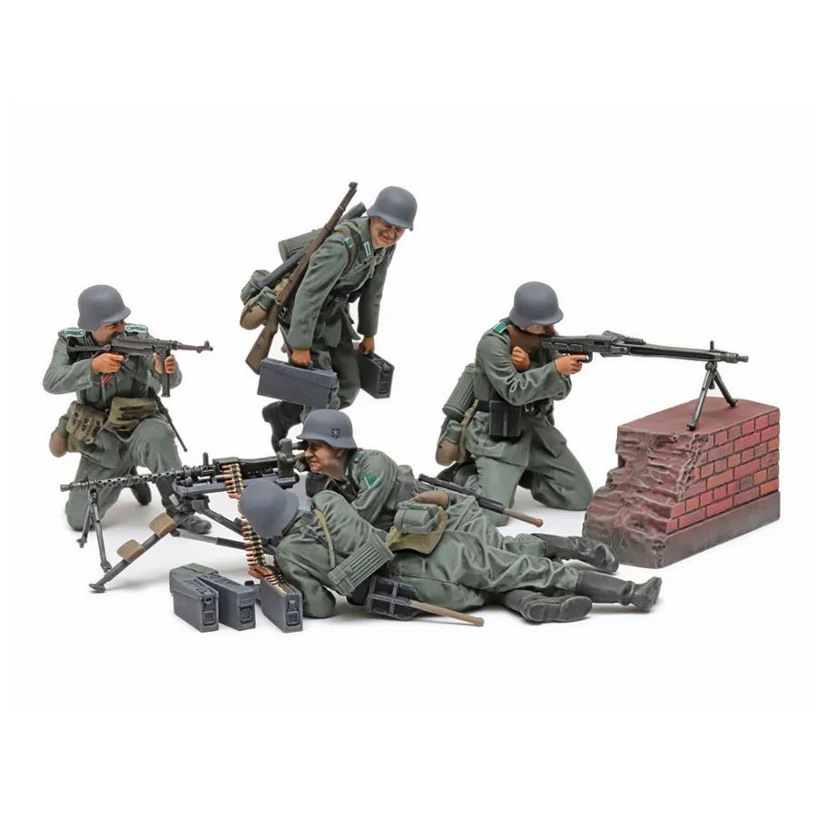 WWII German soldier model kit figures with rifles, machine gun, and brick wall diorama