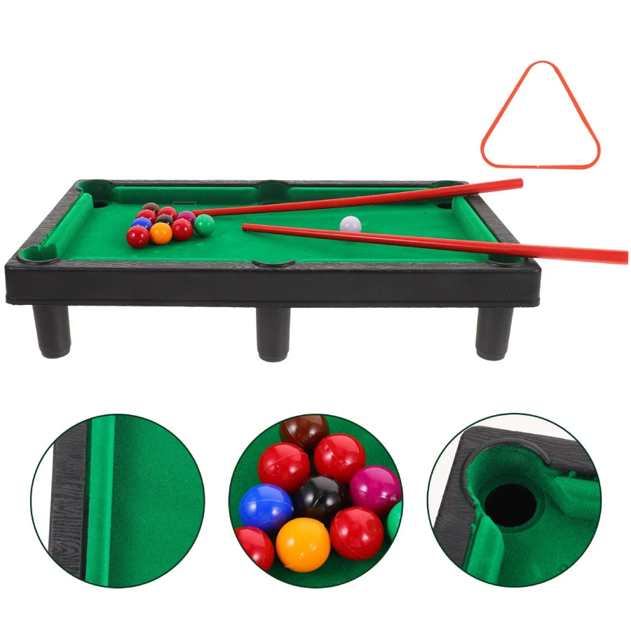 Miniature pool table set with balls, cues, and triangle on a white background