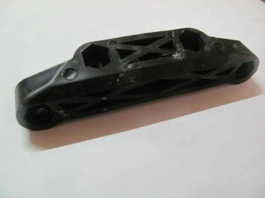Black plastic model car chassis with hexagonal cutouts and mounting holes for RC or scale builds