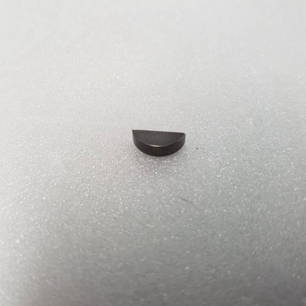 Small black half-moon metal tool part on white foam background
