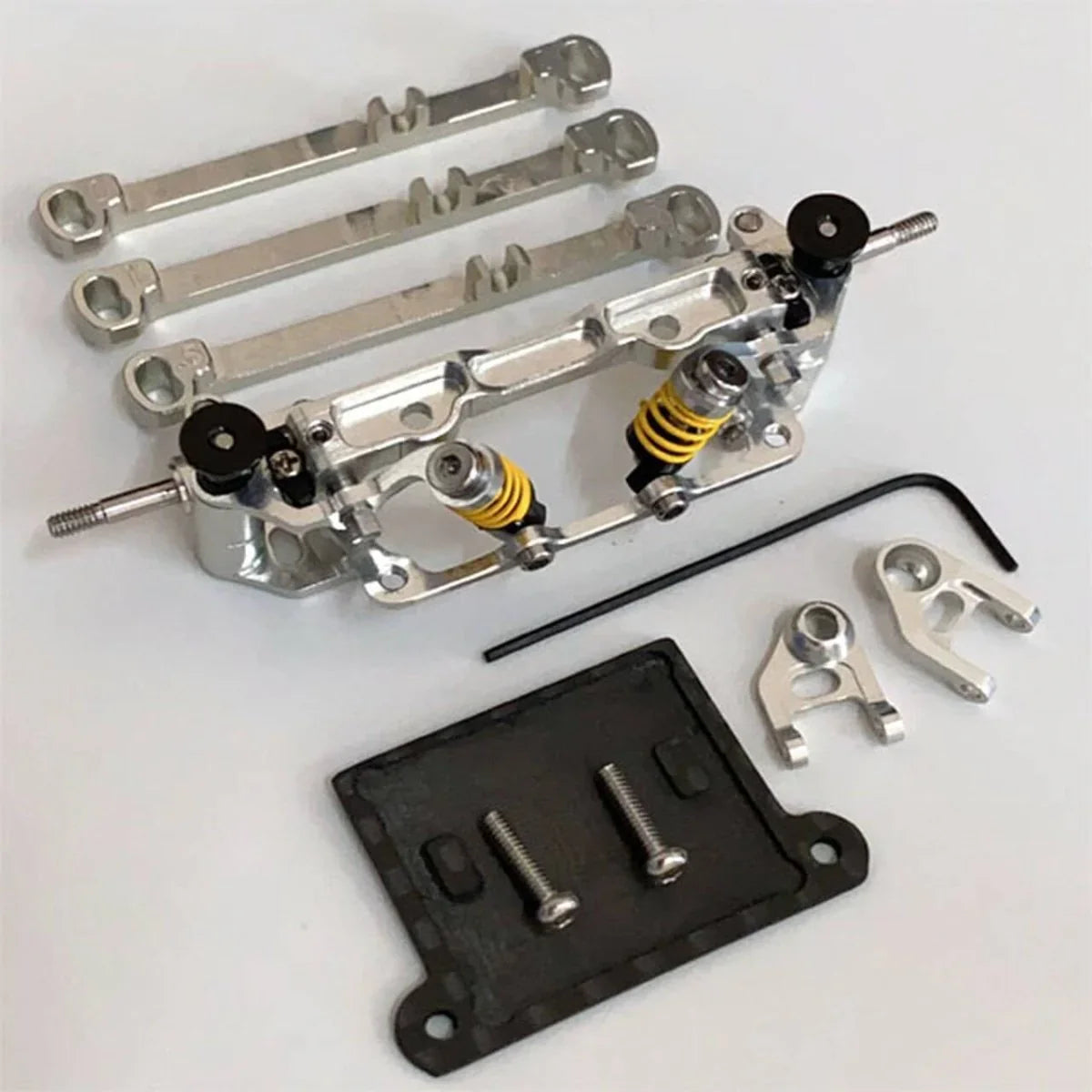RC car aluminum suspension kit with yellow coil springs, linkages, and mounting plate for model assembly