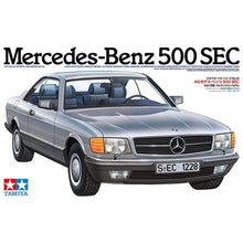 Tamiya 1:24 Mercedes‑Benz 500 SEC kit box front and unassembled grey sprues with V8 engine and chassis parts visible