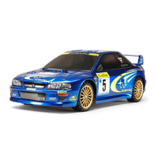 Tamiya 1:10 Subaru Impreza Monte‑Carlo ’99 kit showing blue rally body and gold wheels on TT‑02 chassis